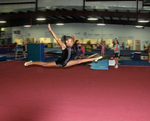 A student does a leap during a practice routine